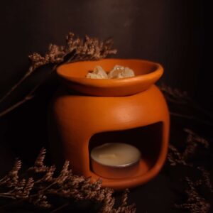quemador de cerámica artesanal con vela tipo tea light en ambiente cálido ritual