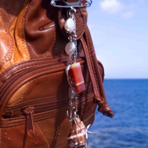 Plea Mar, colgante dorado usado en bolso o prenda, pieza inspirada en la vitalidad y la energía creativa del océano.