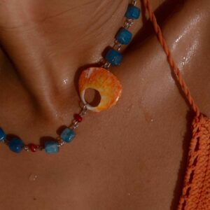 Sunrise, collar de apatita azul y concha marina natural usado en modelo, pieza inspirada en la gratitud y los nuevos comienzos.